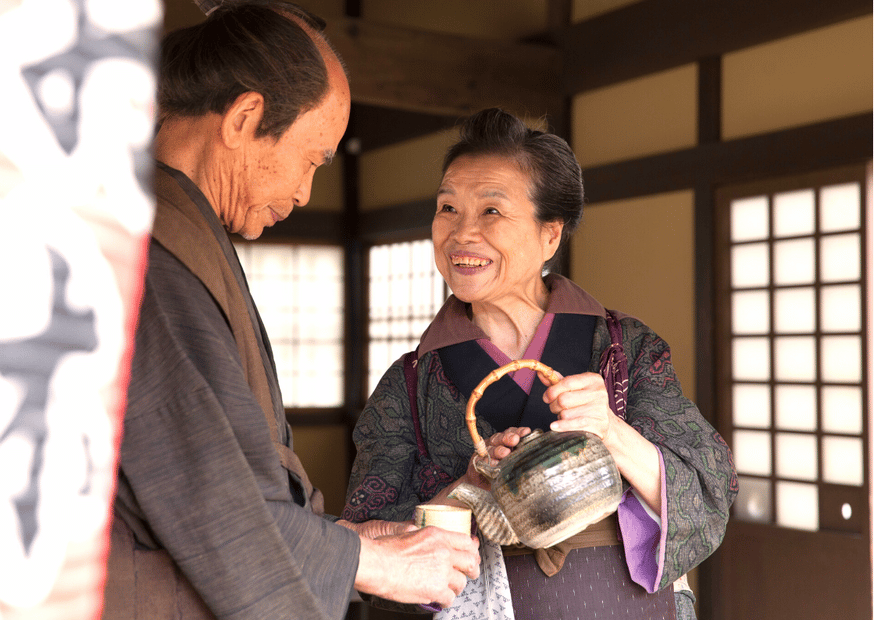 Altes japanisches Ehepaar - sie schenkt Tee aus
