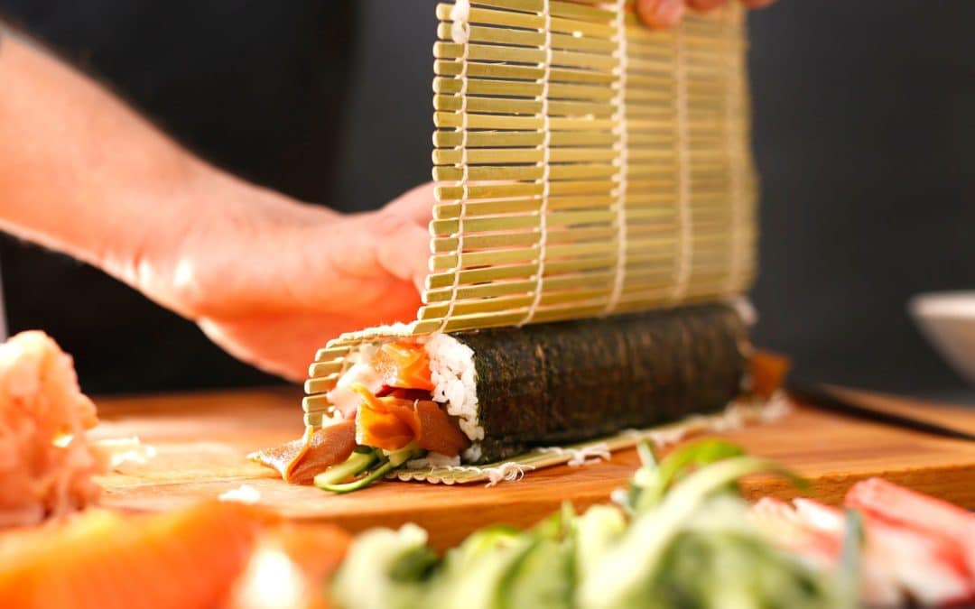 Sushi Koch macht eine große Maki Rolle